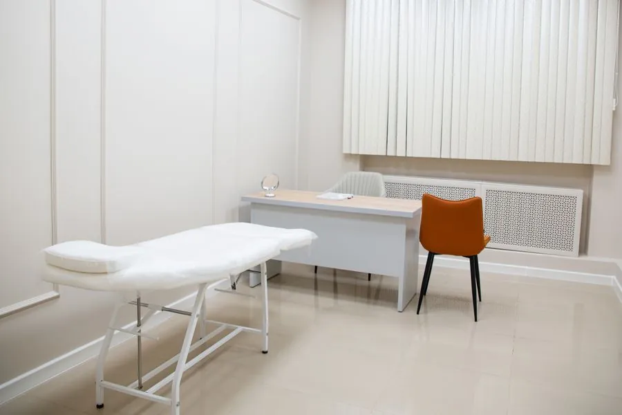 A quiet examination room with a chair by the window